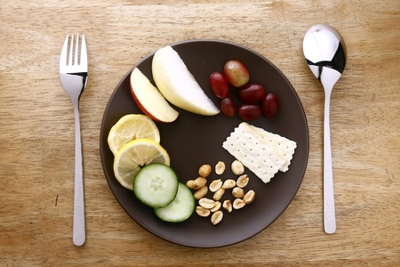Utensils and plate with fruits, vegetables, nuts and crackersの素材