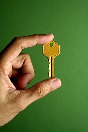Hand holding a golden keyの素材