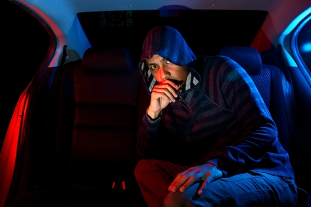 Man in the backseat of a car wearing a hoodie shirtの写真素材