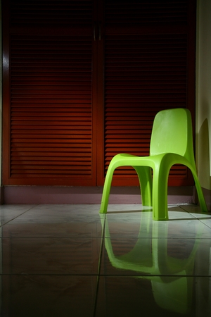 Green plastic chair in a roomの写真素材