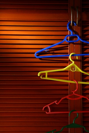 Wooden cabinet door with linked hangers on its metal handleの写真素材