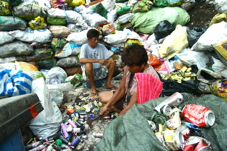 Scavengers at a dump site called Smokey Mountain in Manila Philippines prepares segregated recyclable waste products to be sold to recycling facilitiesのeditorial素材