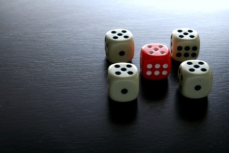 One Red game dice among several white game diceの素材