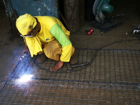 A welder working on a fenceの素材