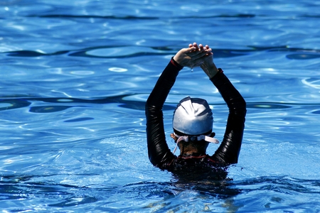 Young kid prepares to swim in a swimming pool.の写真素材