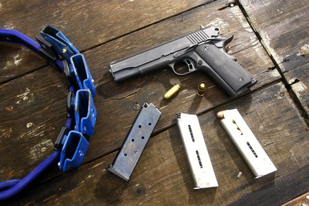 Gun and bullets on a wooden table.
