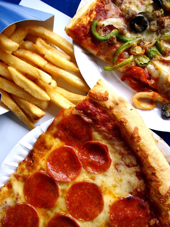 Photo of slices of pizza on a plate and french fries