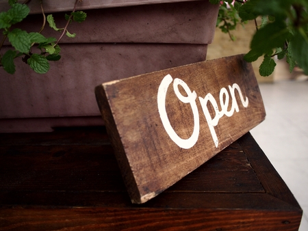 Wooden Open business signage in front of a storeの写真素材