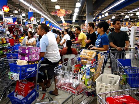 Customers line up for the cashier at a grocery storeの素材