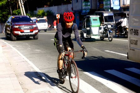 Bikers along an uphill road in Antipolo City, Philippinesの素材