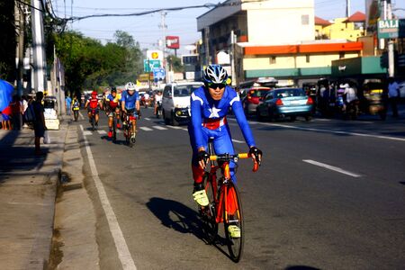 Bikers along an uphill road in Antipolo City, Philippinesの素材
