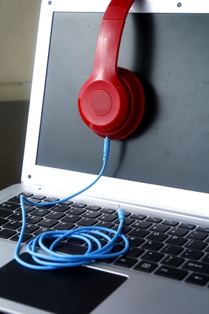 Stereo headphones and a laptop computerの写真素材