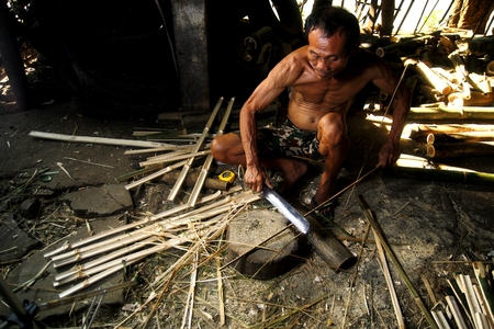 Bamboo furniture maker cutting bambooの写真素材