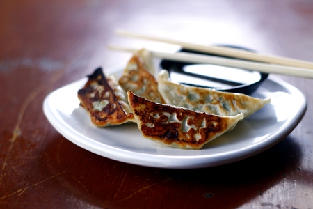 Freshly cooked Gyoza or Japanese pan fried pork dumpling on a plateの写真素材