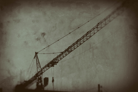 Old construction site with crane on the sunset skyの写真素材