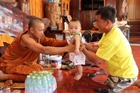 Buddhist monks carrying children in Songkran temple on April 12, 2018 in Thailand.のeditorial素材