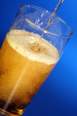 Glass of beer on a blue background.の写真素材