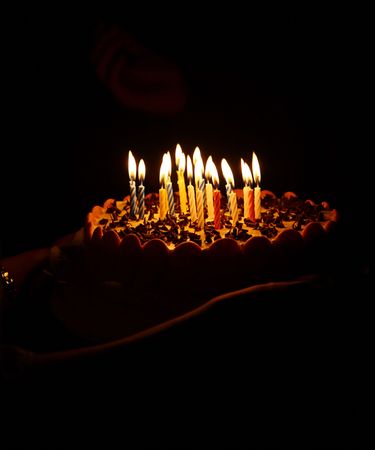 Birthday cake with candles on black.の写真素材