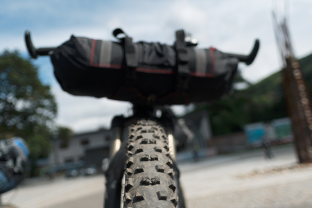 Mountain bike from front wheel in detail with bag on handlebar , blurry backgroundの写真素材