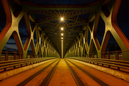 A long exposure of a pedestrian bridge over a river at night. The old bridge. Bratislava, Slovakia. Perspective view.の写真素材
