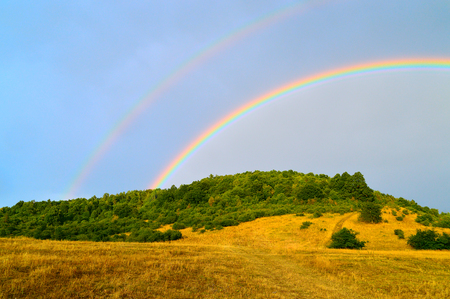 Double rainbow over landscapeの写真素材