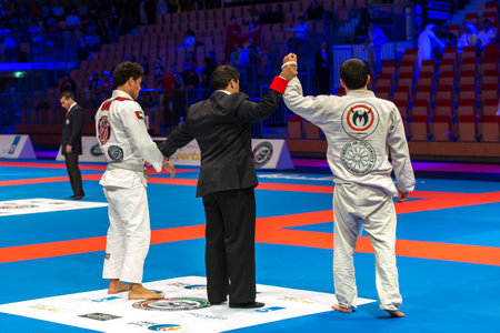 ABU DHABI, UAE - APRIL 19, 2016: ABU DHABI WORLD PROFESSIONAL JIU-JITSU CHAMPIONSHIP 2016 in the IPIC ARENA. The referee announces the winner. Back view.のeditorial素材