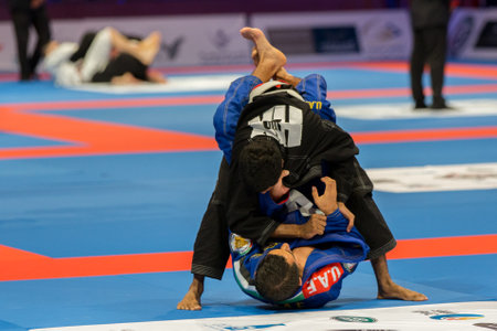 ABU DHABI, UAE - APRIL 19, 2016: ABU DHABI WORLD PROFESSIONAL JIU-JITSU CHAMPIONSHIP 2016 in the IPIC ARENA. Fighters men in blue and black kimonos are fighting.のeditorial素材