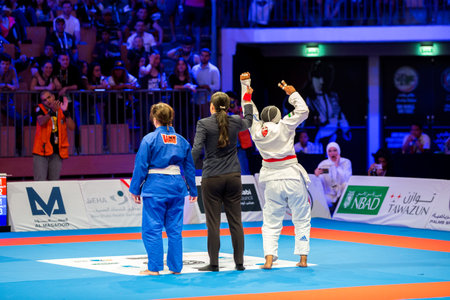 ABU DHABI, UAE - APRIL 19, 2016: ABU DHABI WORLD PROFESSIONAL JIU-JITSU CHAMPIONSHIP 2016 in the IPIC ARENA. The referee announces the female winner. Back view.のeditorial素材