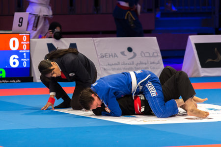 ABU DHABI, UAE - APRIL 19, 2016: ABU DHABI WORLD PROFESSIONAL JIU-JITSU CHAMPIONSHIP 2016 in the IPIC ARENA. Men in blue and black kimonos fighting in the parterre. Referee closely following them.のeditorial素材