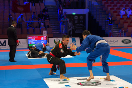 ABU DHABI, UAE - APRIL 19, 2016: ABU DHABI WORLD PROFESSIONAL JIU-JITSU CHAMPIONSHIP 2016 in the IPIC ARENA. Fighters with white belts fighting in the arena.のeditorial素材