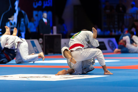 ABU DHABI, UAE - APRIL 19, 2016: ABU DHABI WORLD PROFESSIONAL JIU-JITSU CHAMPIONSHIP 2016 in the IPIC ARENA. Men in white belts and kimonos fighting in the parterre.のeditorial素材