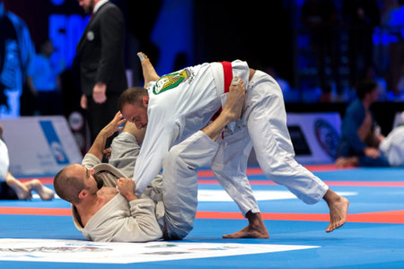 ABU DHABI, UAE - APRIL 19, 2016: ABU DHABI WORLD PROFESSIONAL JIU-JITSU CHAMPIONSHIP 2016 in the IPIC ARENA. Men in white kimonos fighting in the parterre.のeditorial素材
