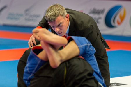 ABU DHABI, UAE - APRIL 19, 2016: ABU DHABI WORLD PROFESSIONAL JIU-JITSU CHAMPIONSHIP 2016 in the IPIC ARENA. Close view of referee following fighters fighting in the parterre.のeditorial素材
