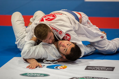 ABU DHABI, UAE - APRIL 19, 2016: ABU DHABI WORLD PROFESSIONAL JIU-JITSU CHAMPIONSHIP 2016 in the IPIC ARENA. Fighters with blue belts fight on the mat.のeditorial素材