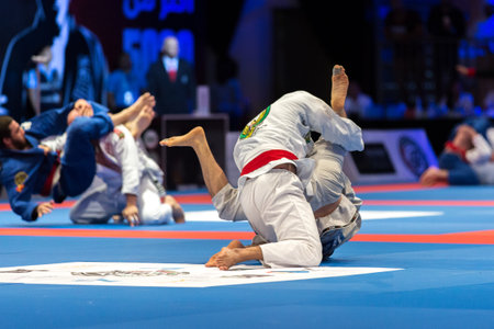 ABU DHABI, UAE - APRIL 19, 2016: ABU DHABI WORLD PROFESSIONAL JIU-JITSU CHAMPIONSHIP 2016 in the IPIC ARENA. Men in white kimonos and belts fighting in the parterre.のeditorial素材