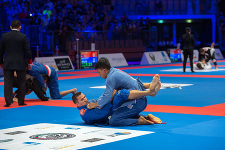 ABU DHABI, UAE - APRIL 19, 2016: ABU DHABI WORLD PROFESSIONAL JIU-JITSU CHAMPIONSHIP 2016 in the IPIC ARENA. Fighters with white belts fighting on the mat in the arena.のeditorial素材