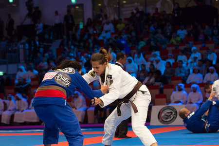 ABU DHABI, UAE - APRIL 19, 2016: ABU DHABI WORLD PROFESSIONAL JIU-JITSU CHAMPIONSHIP 2016 in the IPIC ARENA. Female fighters with brown belts on the mat are fighting.のeditorial素材