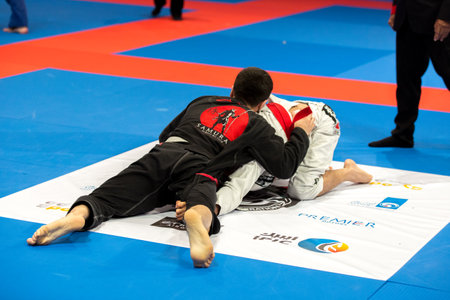 ABU DHABI, UAE - APRIL 19, 2016: ABU DHABI WORLD PROFESSIONAL JIU-JITSU CHAMPIONSHIP 2016 in the IPIC ARENA. Men in white and black kimonos fighting in the parterre.のeditorial素材