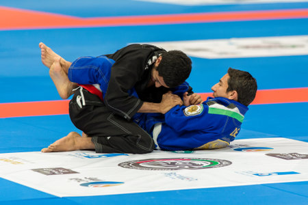 ABU DHABI, UAE - APRIL 19, 2016: ABU DHABI WORLD PROFESSIONAL JIU-JITSU CHAMPIONSHIP 2016 in the IPIC ARENA. Fighters in black and blue kimonos fighting in the parterre.のeditorial素材