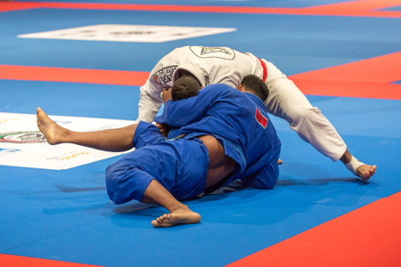 ABU DHABI, UAE - APRIL 19, 2016: ABU DHABI WORLD PROFESSIONAL JIU-JITSU CHAMPIONSHIP 2016 in the IPIC ARENA. Fighters in the kimonos fight in parterre.のeditorial素材