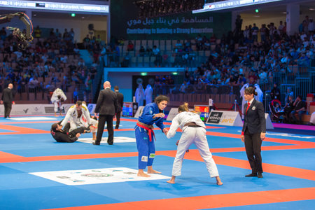 ABU DHABI, UAE - APRIL 19, 2016: ABU DHABI WORLD PROFESSIONAL JIU-JITSU CHAMPIONSHIP 2016 in the IPIC ARENA. Female fighters with brown belts are going to fight on the mat.のeditorial素材