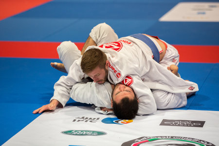 ABU DHABI, UAE - APRIL 19, 2016: ABU DHABI WORLD PROFESSIONAL JIU-JITSU CHAMPIONSHIP 2016 in the IPIC ARENA. Male fighters with blue belts fighting in parterre.のeditorial素材