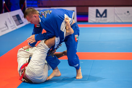 ABU DHABI, UAE - APRIL 19, 2016: ABU DHABI WORLD PROFESSIONAL JIU-JITSU CHAMPIONSHIP 2016 in the IPIC ARENA. Two fighters fight on the mat.のeditorial素材