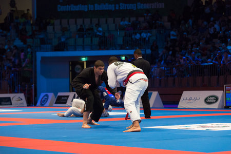 ABU DHABI, UAE - APRIL 19, 2016: ABU DHABI WORLD PROFESSIONAL JIU-JITSU CHAMPIONSHIP 2016 in the IPIC ARENA. Male fighters male on the mat. Beginning of fight.のeditorial素材