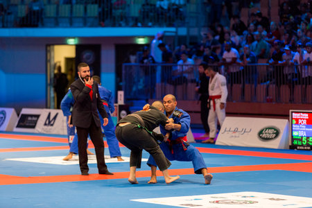 ABU DHABI, UAE - APRIL 19, 2016: ABU DHABI WORLD PROFESSIONAL JIU-JITSU CHAMPIONSHIP 2016 in the IPIC ARENA. Fighters in black and blue kimonos are fighting.のeditorial素材