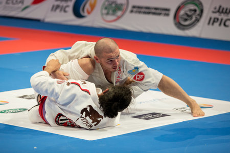 ABU DHABI, UAE - APRIL 19, 2016: ABU DHABI WORLD PROFESSIONAL JIU-JITSU CHAMPIONSHIP 2016 in the IPIC ARENA. Fighters with purple belts fighting in parterre.のeditorial素材
