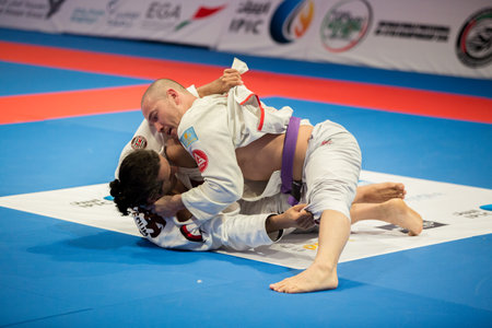 ABU DHABI, UAE - APRIL 19, 2016: ABU DHABI WORLD PROFESSIONAL JIU-JITSU CHAMPIONSHIP 2016 in the IPIC ARENA. Fighters with purple belts fighting in parterre.のeditorial素材