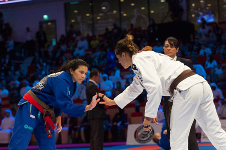 ABU DHABI, UAE - APRIL 19, 2016: ABU DHABI WORLD PROFESSIONAL JIU-JITSU CHAMPIONSHIP 2016 in the IPIC ARENA. Female fighters with brown belts on the mat. The beginning of fight.のeditorial素材