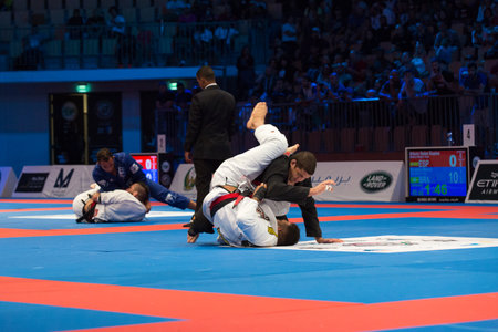 ABU DHABI, UAE - APRIL 19, 2016: ABU DHABI WORLD PROFESSIONAL JIU-JITSU CHAMPIONSHIP 2016 in the IPIC ARENA. Fighters with black belts on the mat.のeditorial素材