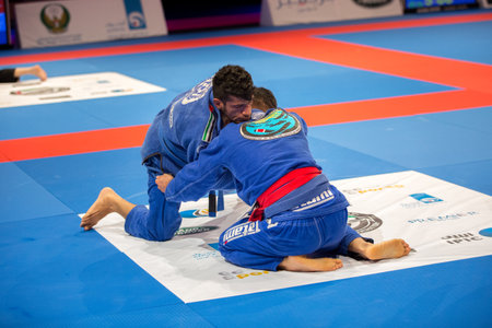 ABU DHABI, UAE - APRIL 19, 2016: ABU DHABI WORLD PROFESSIONAL JIU-JITSU CHAMPIONSHIP 2016 in the IPIC ARENA. Fighters in the blue kimonos fighting in parterre.のeditorial素材